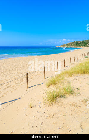 Holzzaun und Rasen auf Sanddüne auf Chia Strand, Insel Sardinien, Italien Stockfoto