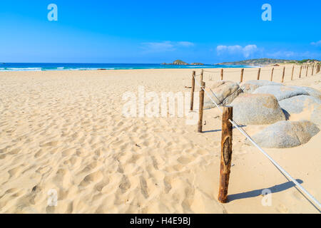 Holzstangen eines Zauns an wunderschönen goldenen Chia Sandstrand, Insel Sardinien, Italien Stockfoto