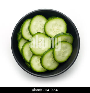 Schwarze Schale mit frischen Gurkenscheiben isoliert auf weißem Hintergrund, Ansicht von oben Stockfoto