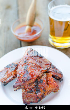 Spareribs auf Grill mit heißen Marinade, tschechisches Bier und Brot Stockfoto