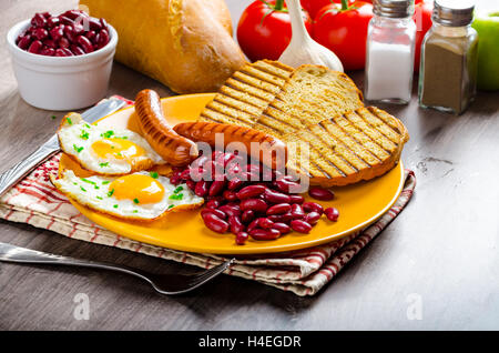 Englisches Frühstück - Knoblauch-Toast, Spiegelei, Bohnen und Bohnenkraut Wurst Stockfoto