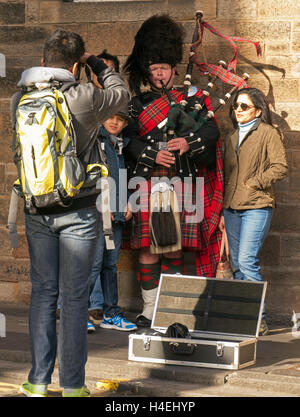 Touristen fotografieren Familie mit traditionellen Schotte in vollen schottischen Insignien, Royal Mile, Altstadt, Edinburgh, Scotland, UK Stockfoto