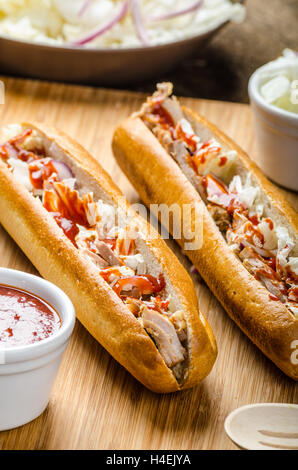 Schweinesandwich, lange gebackenes Schweinefleisch, in frischem Baguette mit frischem Salat und heiße Sause gezogen gezogen Stockfoto