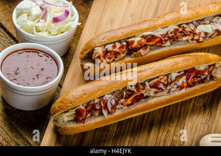 Schweinesandwich, lange gebackenes Schweinefleisch, in frischem Baguette mit frischem Salat und heiße Sause gezogen gezogen Stockfoto