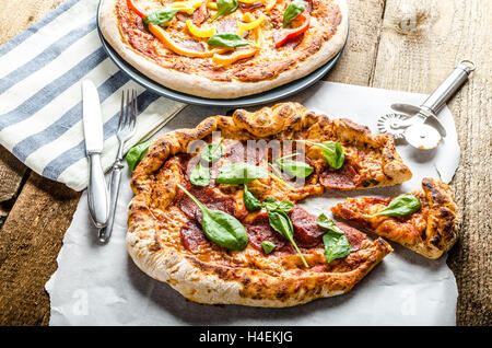 Rustikale Pizza mit Salami und Paprika, verlässt Spinat Stockfoto