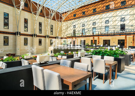 ARLAMOW HOTEL, Polen - 3. August 2014: Tabellen in schöne offene Lobby Restaurant in Arlamow Hotel. Dieses luxuriöse Resort wurde Polens Regierung Besitz und befindet sich im Bieszczady-Gebirge. Stockfoto