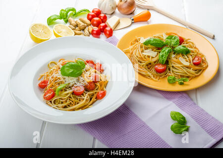 Zitrone-Nudeln mit Cherry-Tomaten, Basilikum und Muttern, 2 Teller, verschiedene servieren Stockfoto