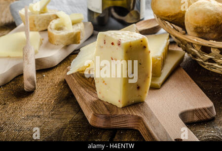 Reifen Käsesorten mit knusprigem Baguette und Wein, Holzplatte Stockfoto