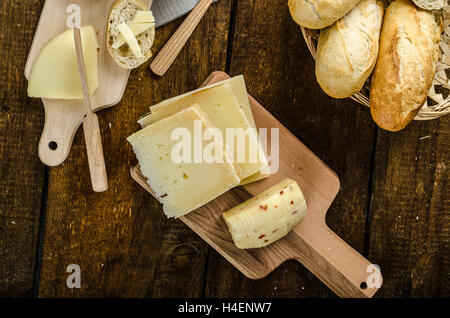 Reifen Käsesorten mit knusprigem Baguette und Wein, Holzplatte Stockfoto