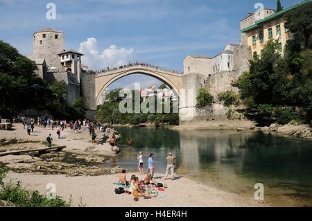 Entspannen am Flussufer vor der Brücke Stari Most Bosnien-Herzegowina. Stockfoto