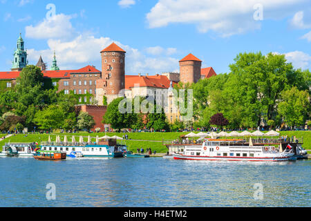 Krakau, Polen - 10. Mai 2014: Touristenboot auf Weichsel vor Wawel Königsschloss auf schönen Sonnentag, Polen. Krakau ist die meistbesuchte Stadt in Polen von Touristen. Stockfoto