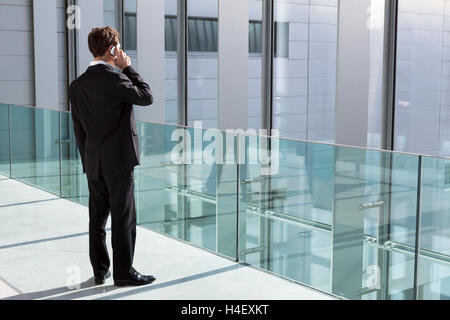 Geschäftsmann telefonieren mit neuer Technologie Smartphone in der modernen Bürogebäude Stockfoto