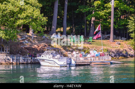 Kingston, Kanada - 3. September 2016: One Island mit dem weißen Haus mit einem weißen Boot in Thousand Islands Region im Sommer Stockfoto