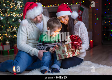 Urlaub, Geschenke, Weihnachten Konzept - glückliche Mutter, Vater und Kind Junge mit Geschenk-box Stockfoto