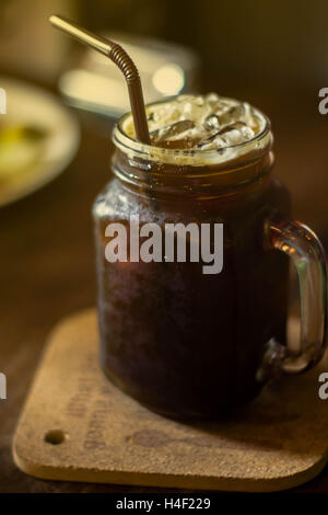 großes Glas Eiskaffee kalten Kakao (Mokka) mit braunem Papier Becherhalter - Nahaufnahme - Innenbeleuchtung Stockfoto