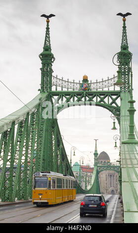 Gelben Straßenbahn auf der Freiheitsbrücke oder Freiheit Brücke in Budapest, Ungarn. Stockfoto