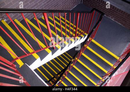 Blick nach unten eine Treppe mit fluoreszierenden Sicherheitsleisten gemalt am Rande eines jeden beschreiten. Stockfoto