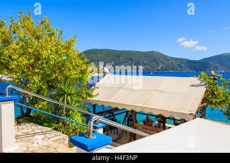 FISKARDO, KEFALONIA - SEP 18, 2014: Traditionelle griechische Taverne in Fiskardo Hafen, Insel Kefalonia, Griechenland. Griechenland ist bekannt für gutes Essen und sonniges Wetter. Stockfoto