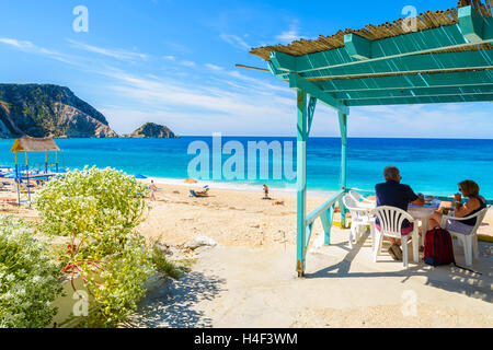 Nicht identifizierte paar Touristen sitzen in traditionelle griechische Taverne am Petani Beach, Insel Kefalonia, Griechenland Stockfoto