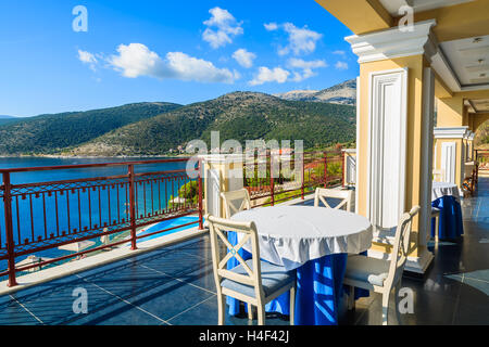 Tisch mit Stühlen auf der Terrasse auf der Küste von Kefalonia Insel im Dorf Agia Efimia, Griechenland Stockfoto