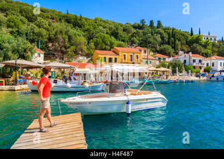 KIONI Hafen, Insel ITHAKA - SEP 19, 2014: junge Frau Tourist auf hölzernen Steg im Hafen Kioni stehen. Griechenland ist ein sehr beliebtes Urlaubsziel in Europa. Stockfoto