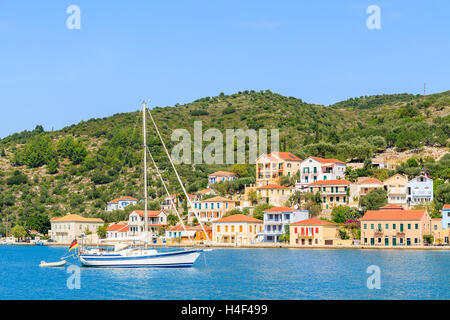 Yacht Boot am Meer mit bunten Häusern der Stadt Vathi im Hintergrund die Insel Ithaka, Griechenland Stockfoto