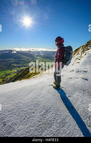 Weibliche Hillwalker auf Blencathra (Saddleback) im Winter blickte Halls Fell Ridge Johanniskirche im Tal. Stockfoto