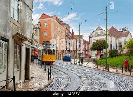 Die Abfahrt gewundenen Rua Limoeiro ist landschaftlich sehr reizvoll mit einer gelben Straßenbahn, das ist, warum Touristen gerne hier spazieren gehen. Stockfoto