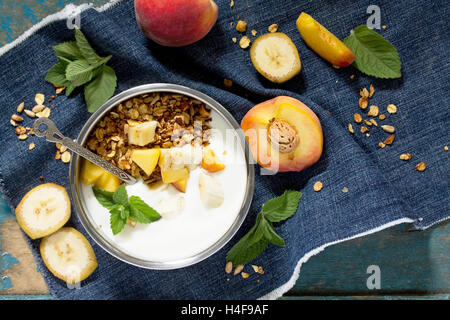 Gesundes Frühstück mit Müsli, Beeren mit Joghurt und Samen auf ein Vintage Holz-Hintergrund - Essen Detox Diät, Ansicht von oben. Stockfoto