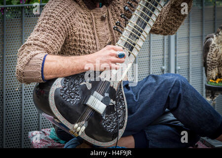 Straßenmusikanten ein Grand Pro Tun Sitar in Abington Street, Northampton Town Centre eine indische Instrument zu spielen. Stockfoto