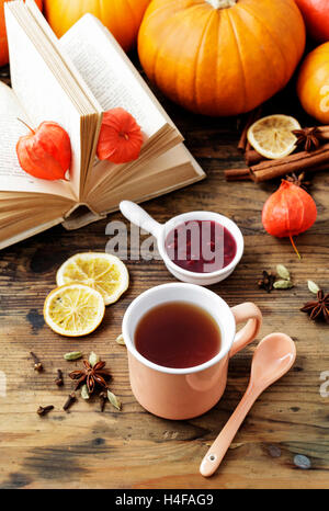 Jasmin-Tee in Keramik Krug auf Holztisch steht. Herbstliche Dekorationen rund um. Stockfoto