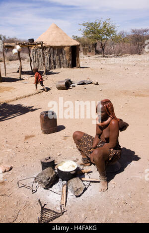 Himba Frau bei der Herstellung von Butter in der traditionellen Weise, Nord-namibia Stockfoto