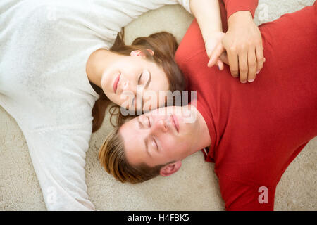 junge schöne Paar liegen auf Teppich und schläft Stockfoto