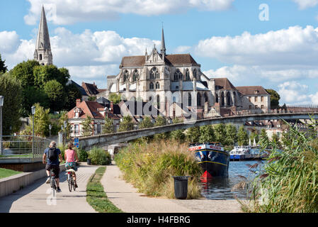 Besucher, die Radfahren in Richtung d'Auxerre der Abbaye de Saint-Germain in Auxerre auf dem Treidelpfad am Ufer des Flusses Yonne, Burgund, Frankreich Stockfoto