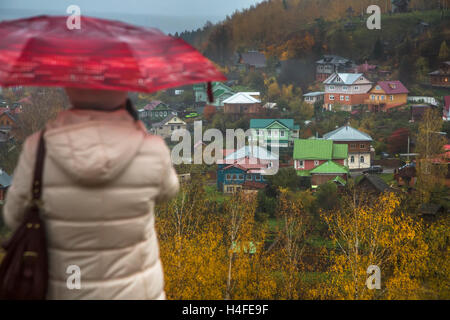 Eine Frau unter einem Regenschirm Blick hinunter auf die alte russische Stadt Ples in Ivanovo Region im Herbst Regen, Russland Stockfoto