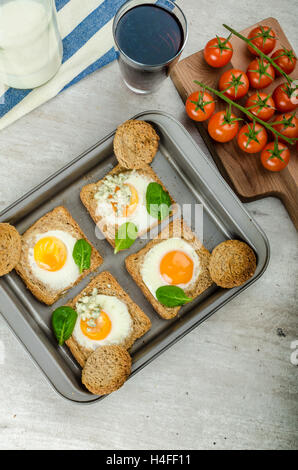 Gebackene Bullauge Eiern auf Vollkorn Toast mit Spinat und Blauschimmelkäse an der Spitze Stockfoto