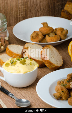 Panierte Champignons gebraten mit frisch gepresstem Orangensaft und hausgemachte Remoulade Stockfoto