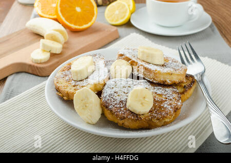 Rench Toast zu süß, mit Banane, bestreut mit Zucker, frischer Tee, Frühstück Stockfoto