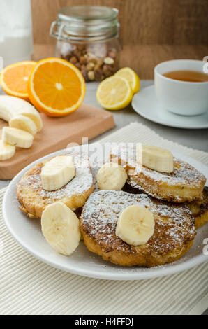 Rench Toast zu süß, mit Banane, bestreut mit Zucker, frischer Tee, Frühstück Stockfoto