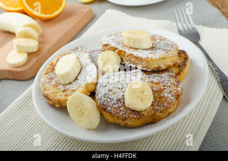 Rench Toast zu süß, mit Banane, bestreut mit Zucker, frischer Tee, Frühstück Stockfoto