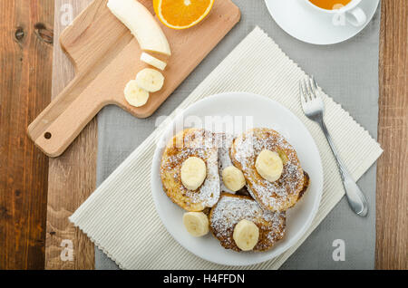 Rench Toast zu süß, mit Banane, bestreut mit Zucker, frischer Tee, Frühstück Stockfoto