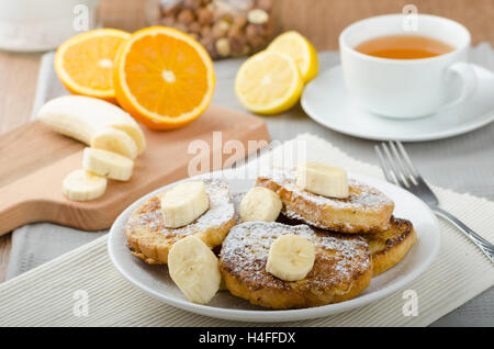 Rench Toast zu süß, mit Banane, bestreut mit Zucker, frischer Tee, Frühstück Stockfoto