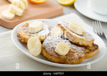 Rench Toast zu süß, mit Banane, bestreut mit Zucker, frischer Tee, Frühstück Stockfoto