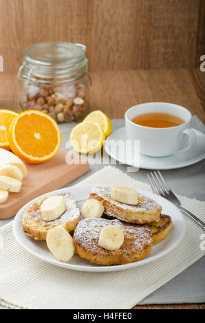 Rench Toast zu süß, mit Banane, bestreut mit Zucker, frischer Tee, Frühstück Stockfoto