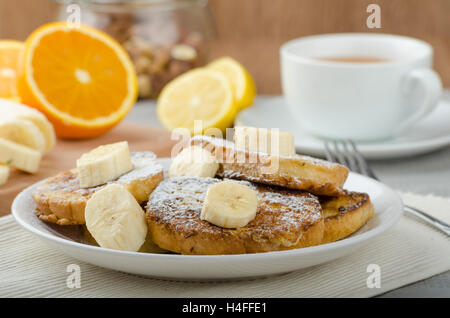 Rench Toast zu süß, mit Banane, bestreut mit Zucker, frischer Tee, Frühstück Stockfoto