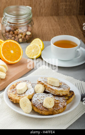 Rench Toast zu süß, mit Banane, bestreut mit Zucker, frischer Tee, Frühstück Stockfoto