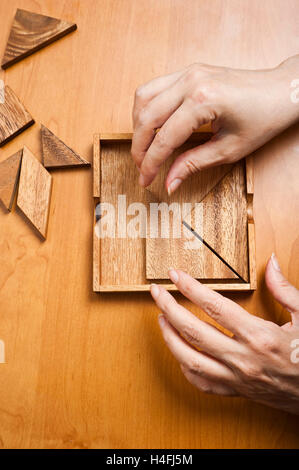 Hände einer Frau, die das Spiel Tangram Stockfoto