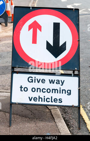 Ein temporäres Schild warnt Fahrer entgegenkommender Fahrzeuge weichen. Stockfoto