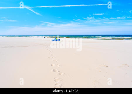 Fußspuren im Sand am Strand von Debki mit Windbreaker in Ferne, Ostsee, Polen Stockfoto