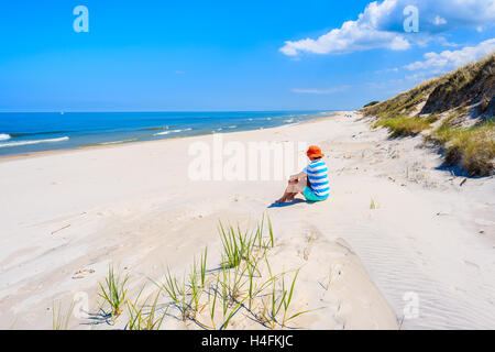 Junge Frau Touristen sitzen in Sand am leeren Strand in Bialogora, Ostsee, Polen Stockfoto